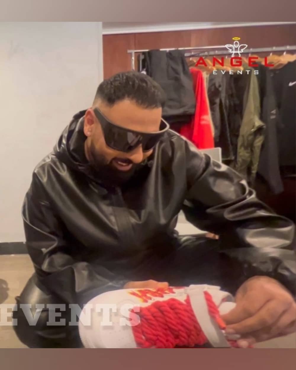 Celebrity Rap artist singer: Badshah holding his custom hand painted Nike sneakers