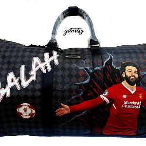 Footballer Mohamed Salah from Liverpool LFC's portrait hand painted on a large duffle bag with his name and a football