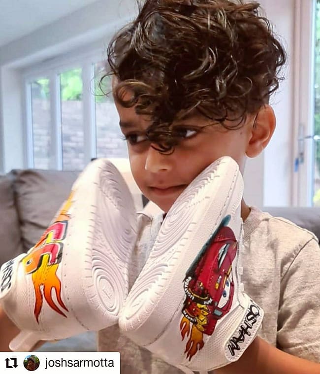 Cute boy holding a pair of kids personalised Cars Lightening McQueen Nike sneakers