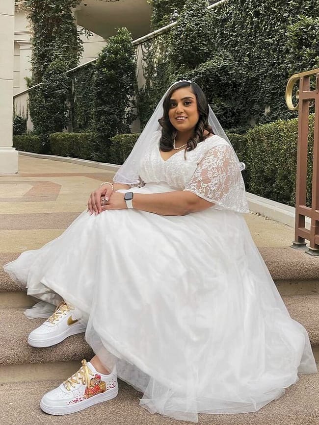Bride in white dress wearing hand painted custom bridal Nike AF1 sneakers