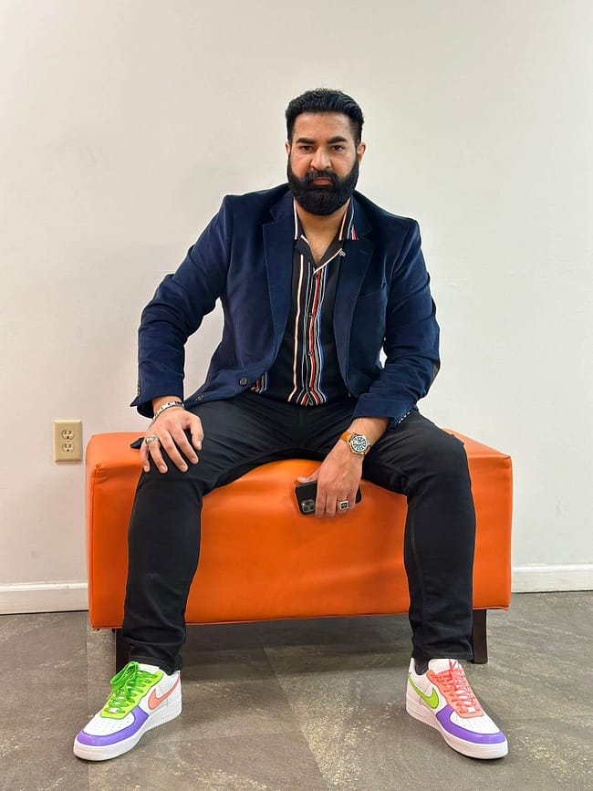 Man sitting wearing colourful neon hand painted Nike AF1 sneakers