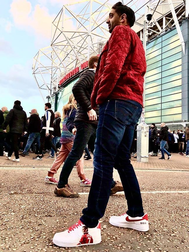 Man standing outside Manchester United football stadium wearing his custom hand painted Eric Cantona Nike AF1 sneakers