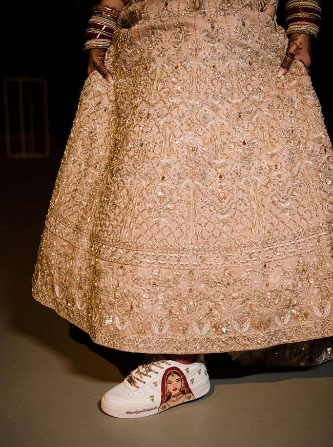 Indian bride in gold lehenga wearing hand painted bridal Nike AF1 sneakers with bride portrait