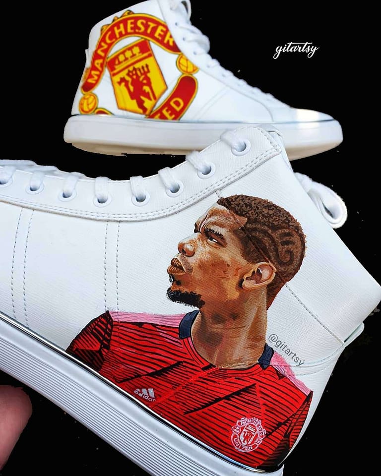 A realistic portrait of Paul Pogba and Manchester United logo hand painted on high-top white sneakers KICKS