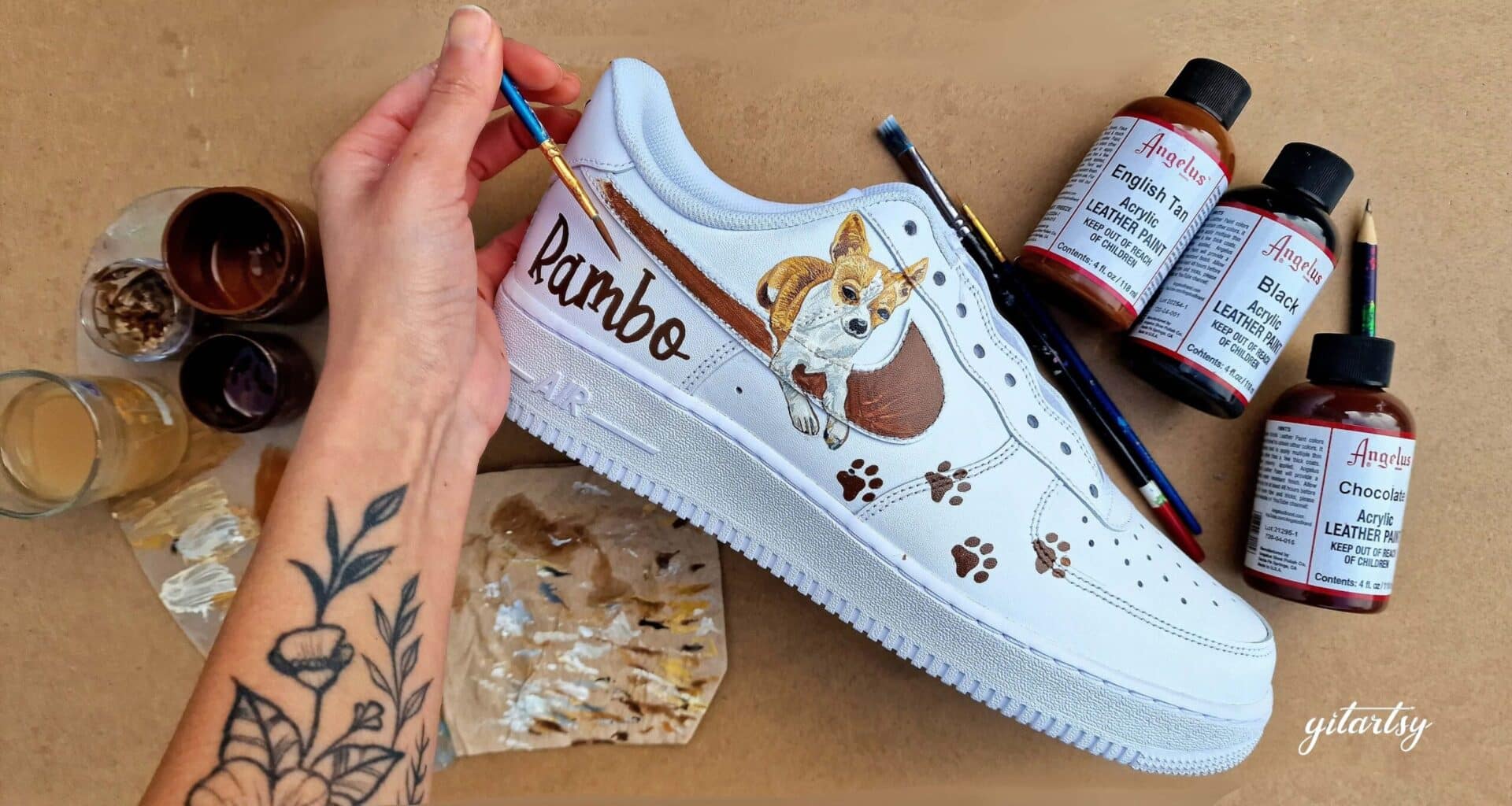 Gitartsy painting a custom pet dog portrait on a pair of white Nike AF1 sneakers